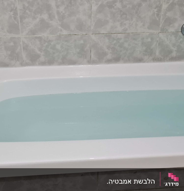 אמבטיה מלאה במים עם ברז ומגבת נייר